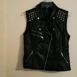 Black spiked studded vest with multiple zippers.